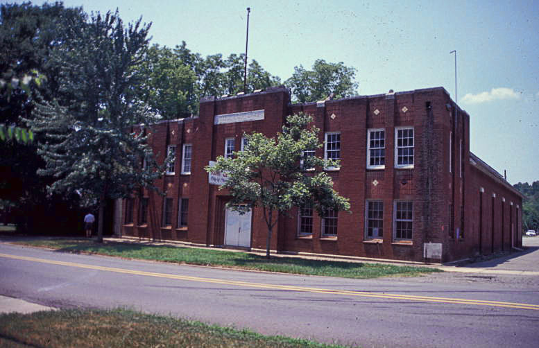 Two-story brick building with rectangular windows and square panes on street