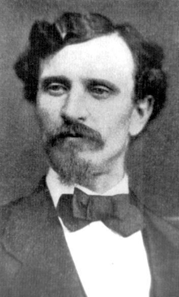 White man with a beard and mustache in suit and bow tie