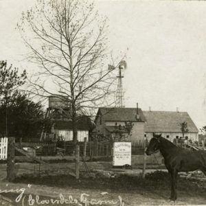 Farmer and horse with house and barns in the background