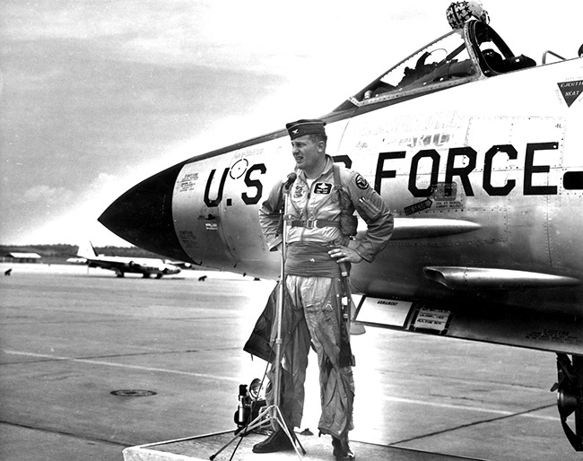 White man in pilot's uniform with cap and U.S. Air Force jet