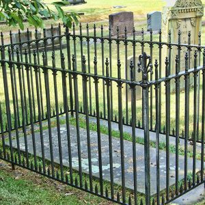 Iron fence around engraved grave ledger in cemetery
