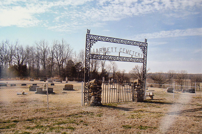 Cemetery with fence and iron gate with stone columns