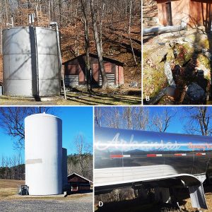 A. Shed and water silo tankB. Shed with spring pouring from pipeC. Water tanks and shedD. "Arkansas Spring Water" tanker trailer