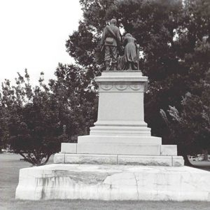 Rear view of stone monument with statues atop pedestal