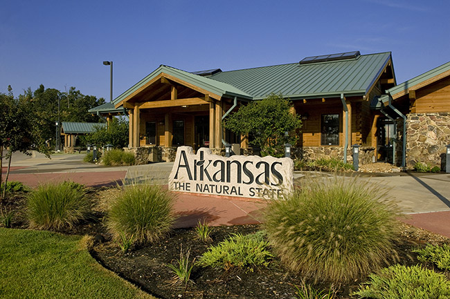 Wood and stone building with "Arkansas the natural state" sign