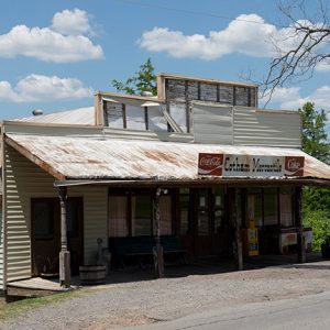 "Cotham Mercantile" sign on old store with covered porch with lake in the distance
