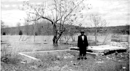 White man in suit standing in a flooded field