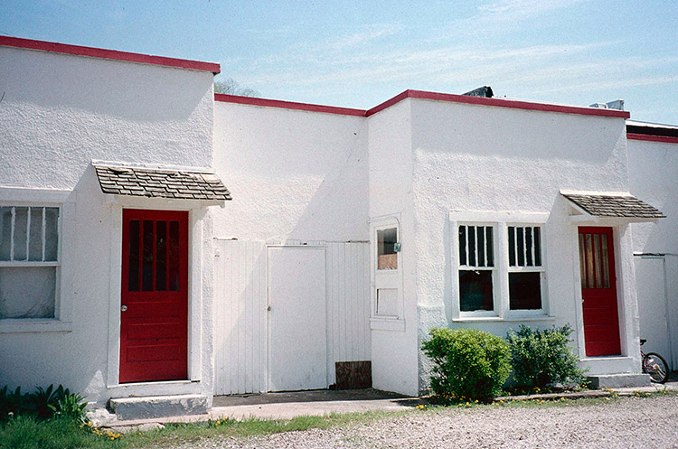 Red and white apartment building on gravel