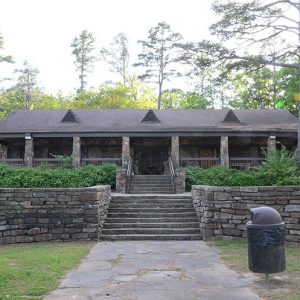 Single-story building with covered porch with steps between two brick walls