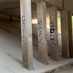 "Covid Hoax 2020" graffiti on bridge supporting columns