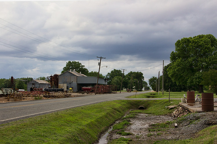 Multistory farm buildings and machinery on two-lane road