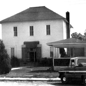 Two-story wooden building with gazebo and Chevrolet truck