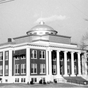 Three-story building with large round dome capped with a flagpole