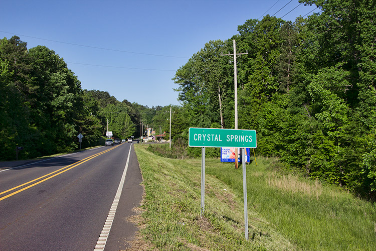 Two-lane highway with green "Crystal Springs" sign on the right