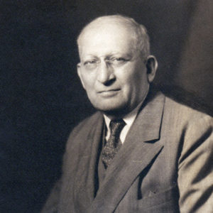 Old white man with glasses in suit and tie