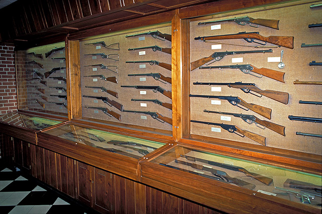 Rows of guns in display cases behind glass