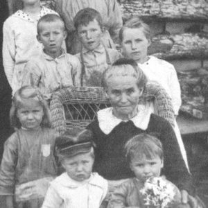 Old white woman sitting with group of white children