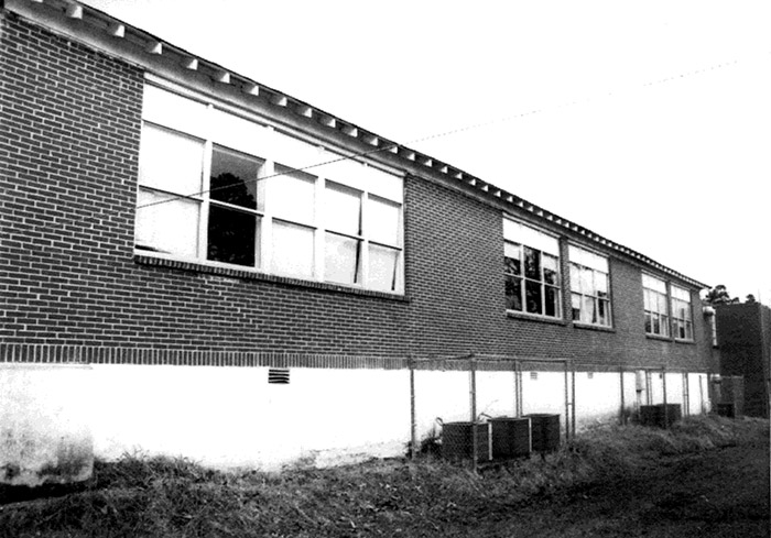 Side of brick school building with air conditioning units