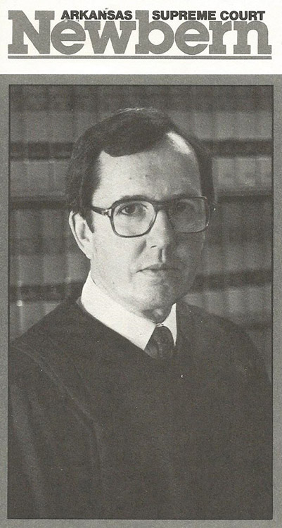 White man with glasses in judge's robes on campaign card