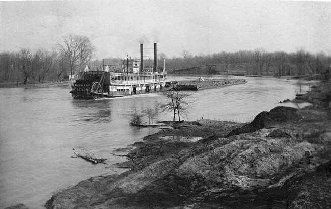 steamboat pushing barge on river