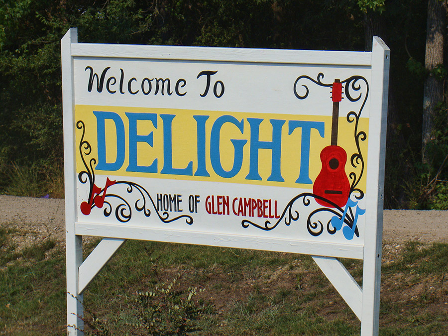 "Welcome to Delight Home of Glen Campbell" sign with guitar art