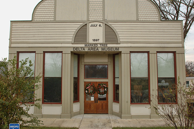 Single-story building with tall windows and double doors "Delta Area Museum"