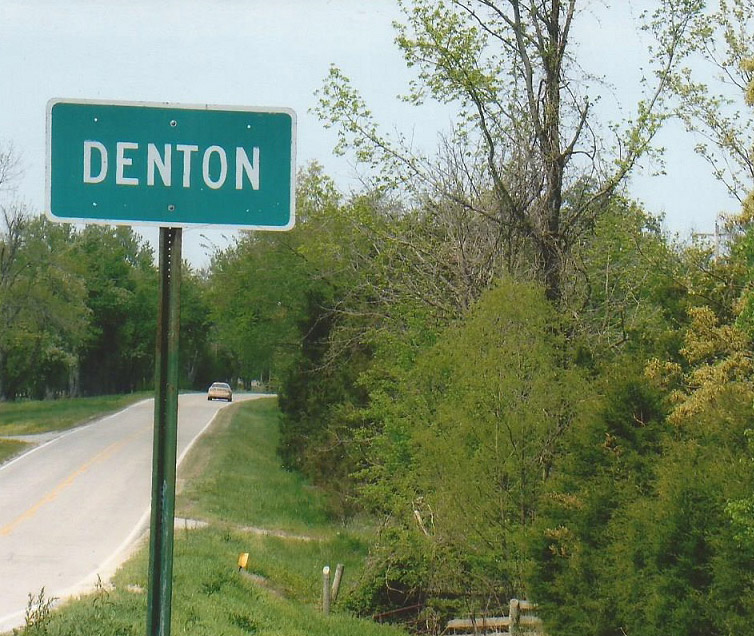 Green "Denton" sign on two-lane road