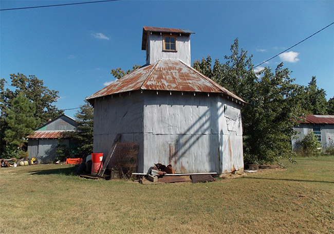 Barn and gin with rusted metal roof and cupola