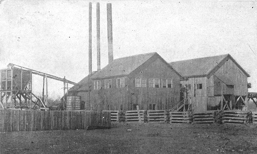 Two wooden buildings with smokestacks