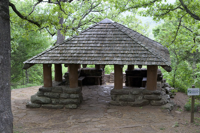 Stone and wood pavilion surrounded by trees