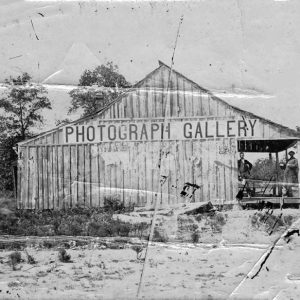 Single-story ramshackle building with "Photograph Gallery" sign on its side