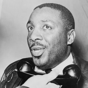 Young African-American man with white man holding a phone receiver to his mouth