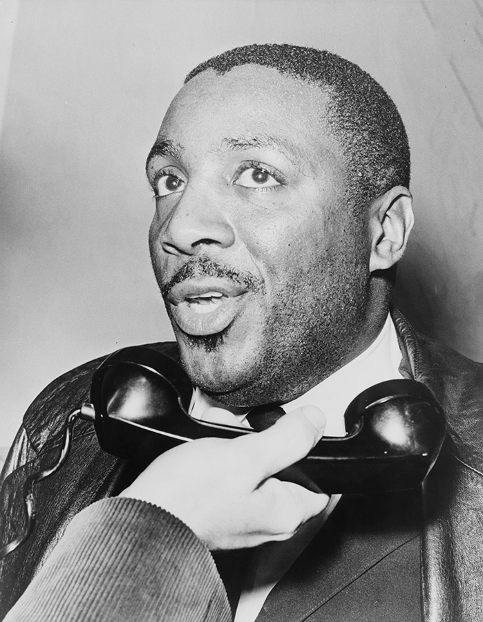 Young African-American man with white man holding a phone receiver to his mouth