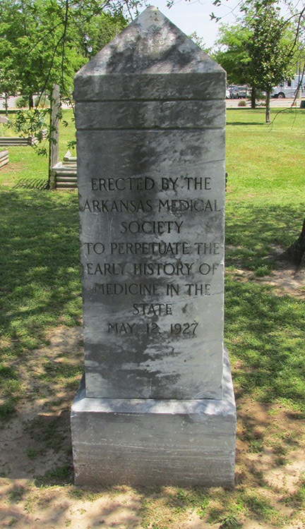 "Erected by the Arkansas Medical Society to perpetuate the early history of medicine in the state May twelfth Nineteen Twenty-Seven" inscription on stone obelisk in park