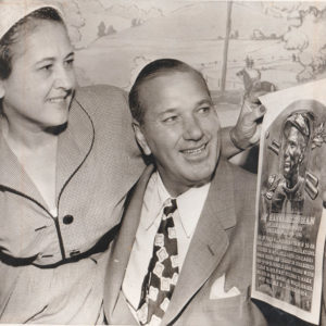 White man and woman examining image on sheet of paper