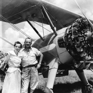 White man and woman with biplane