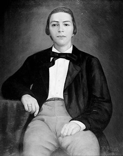 Young white man sitting down in suit and bow tie