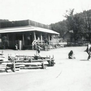 Children playing in theme park with western style buildings and wooden fences