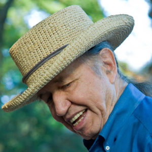 Older white man in straw hat and blue shift