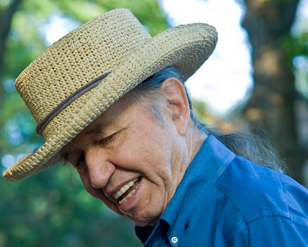 Older white man in straw hat and blue shift