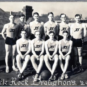 Group of young white men pose for a group photo in shorts and tank tops with basketball