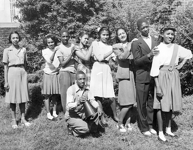 African-American boys and girls posing outside brick building