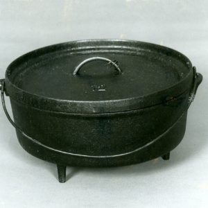 Large black Dutch oven of cast iron with lid and handle on a white background