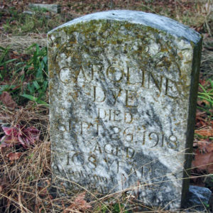 Weathered "Caroline Dye" gravestone in cemetery