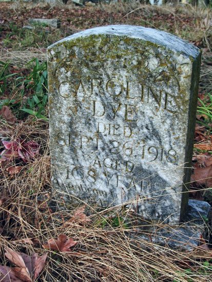 Weathered "Caroline Dye" gravestone in cemetery