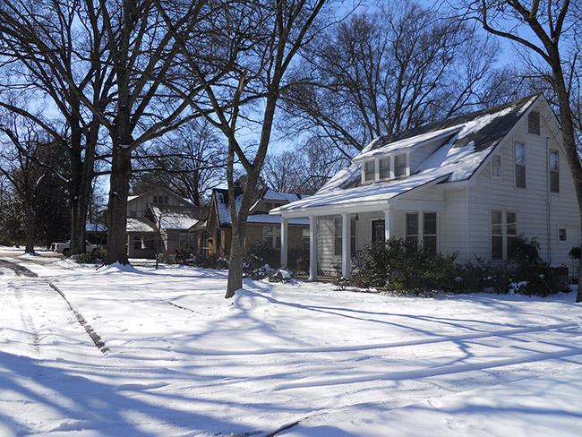 Two-story white house and neighborhood in snow