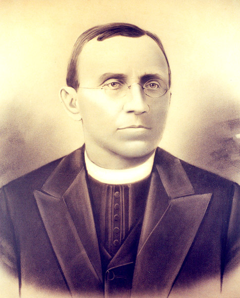 white man in priest's collar and glasses