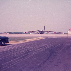 Large airplane on airstrip with truck in foreground
