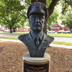 Bust of white man in military uniform with cap on round pedestal with plaque