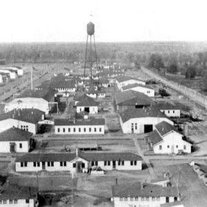 Complex of buildings in rows with water tower and airstrip